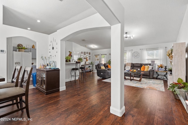 interior space with a textured ceiling, dark hardwood / wood-style floors, vaulted ceiling, and a healthy amount of sunlight