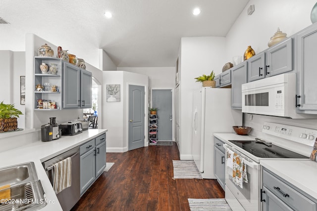 kitchen featuring gray cabinetry, white appliances, and dark hardwood / wood-style floors