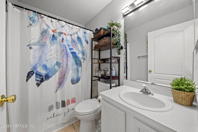 bathroom featuring a textured ceiling, a shower with curtain, tile patterned floors, vanity, and toilet