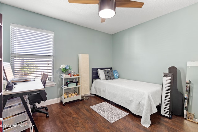 bedroom featuring ceiling fan, a textured ceiling, and dark wood-type flooring