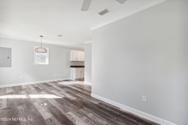 spare room featuring ceiling fan, electric panel, dark hardwood / wood-style floors, and crown molding