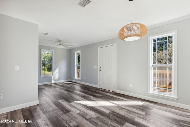 empty room with ceiling fan, crown molding, dark wood-type flooring, and a wealth of natural light