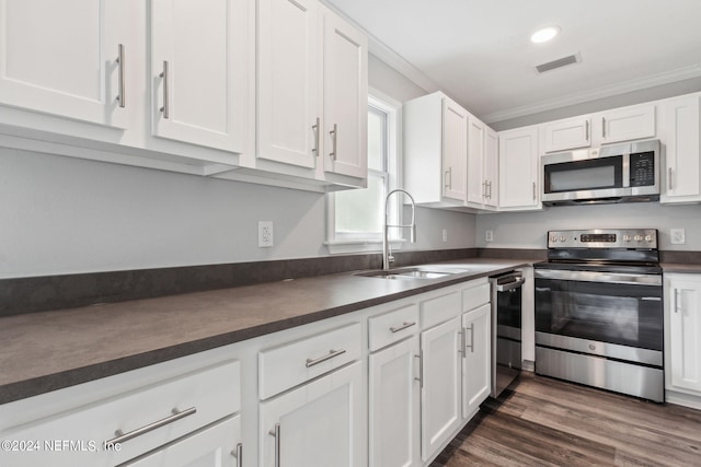 kitchen featuring dark hardwood / wood-style floors, sink, white cabinets, appliances with stainless steel finishes, and ornamental molding