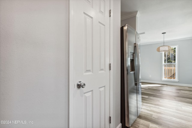 hallway with crown molding and light hardwood / wood-style floors