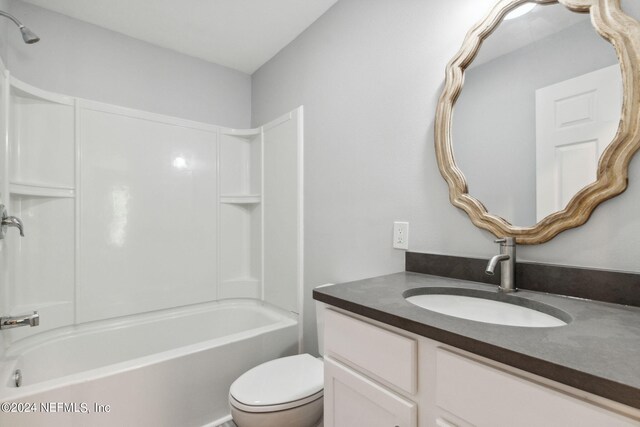 full bathroom featuring tub / shower combination, vanity, and toilet