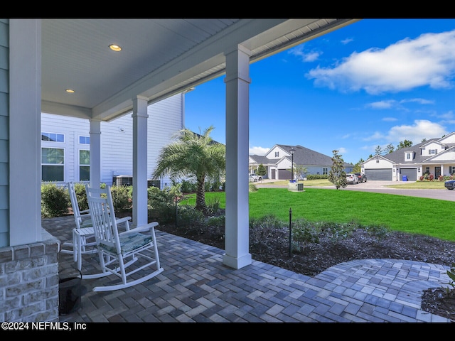 view of patio featuring a garage and a porch