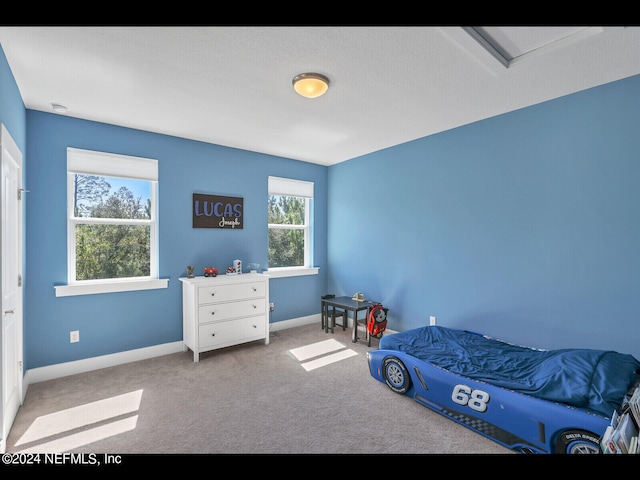 bedroom featuring light colored carpet and a textured ceiling