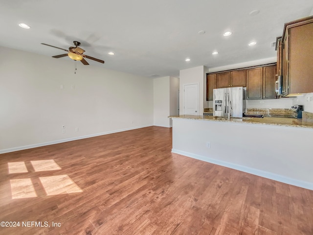 kitchen featuring light stone countertops, stainless steel appliances, and light wood-type flooring