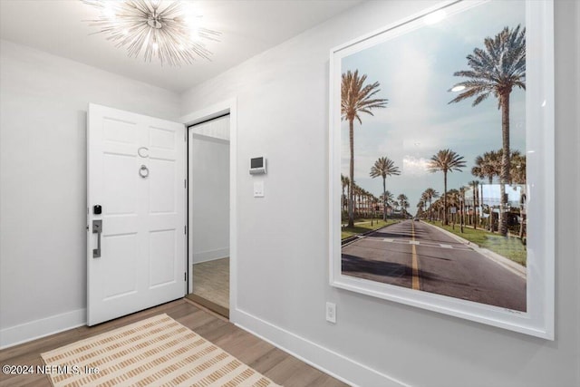 entryway featuring an inviting chandelier and wood-type flooring