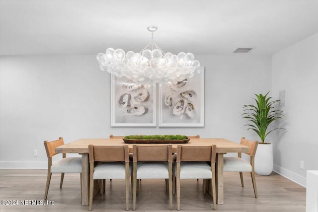 dining space with an inviting chandelier and hardwood / wood-style floors