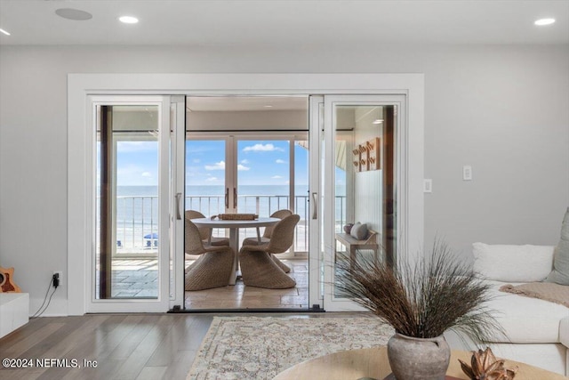 doorway to outside with a water view and dark hardwood / wood-style floors