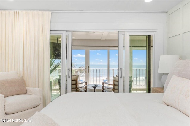 bedroom with a beach view, access to exterior, and a water view