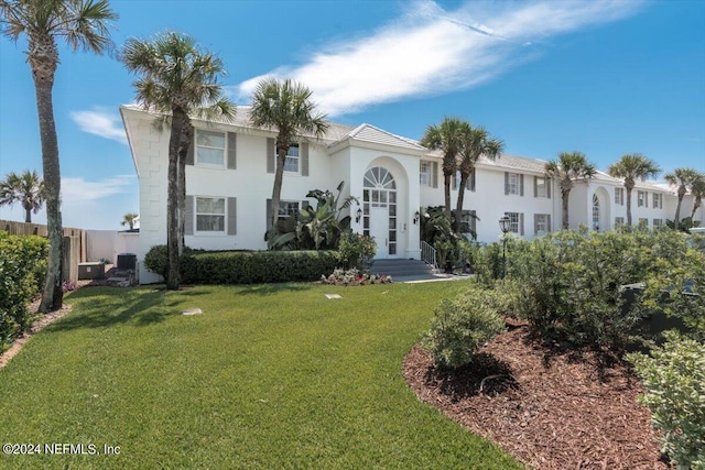 mediterranean / spanish house with cooling unit and a front yard