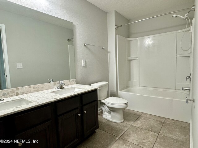 full bathroom featuring tile patterned flooring, a textured ceiling, toilet, vanity, and bathtub / shower combination