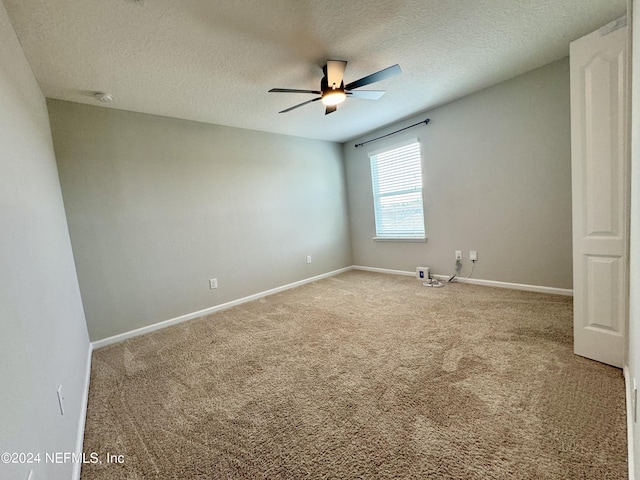 carpeted empty room featuring ceiling fan and a textured ceiling