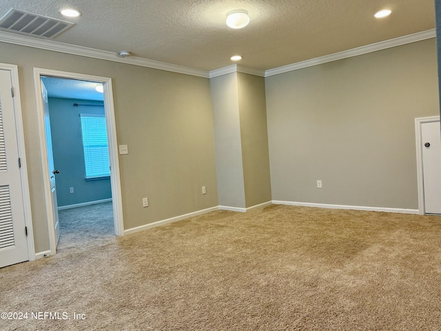 carpeted empty room with crown molding and a textured ceiling