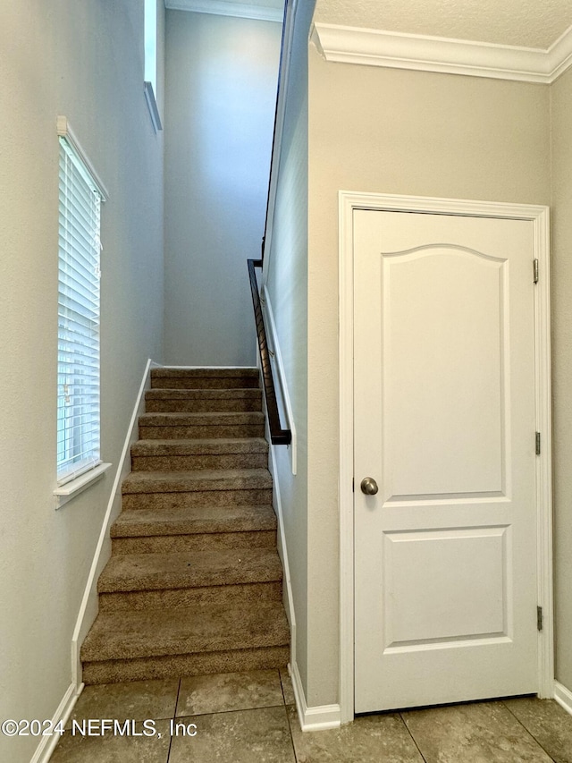 stairs featuring tile patterned flooring and ornamental molding