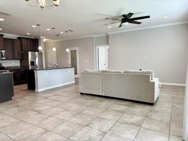 tiled living room featuring a textured ceiling, crown molding, sink, and ceiling fan with notable chandelier