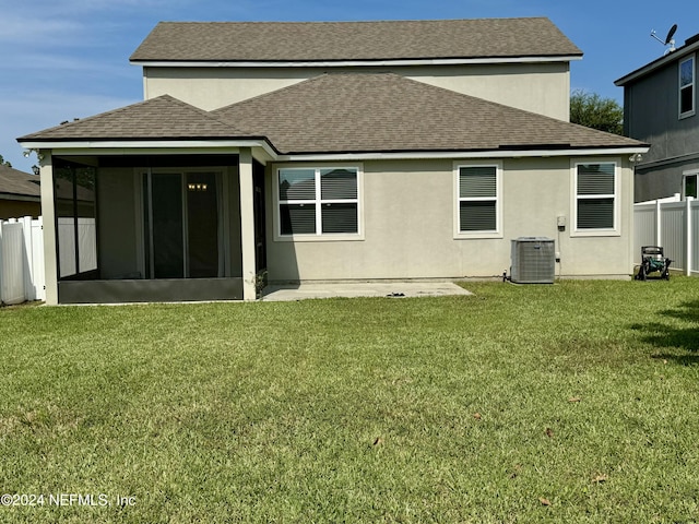 back of house with a lawn, a sunroom, cooling unit, and a patio