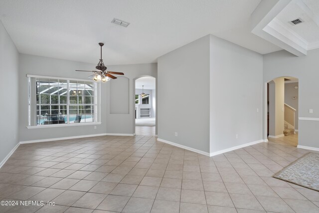 spare room with ceiling fan and light tile patterned floors