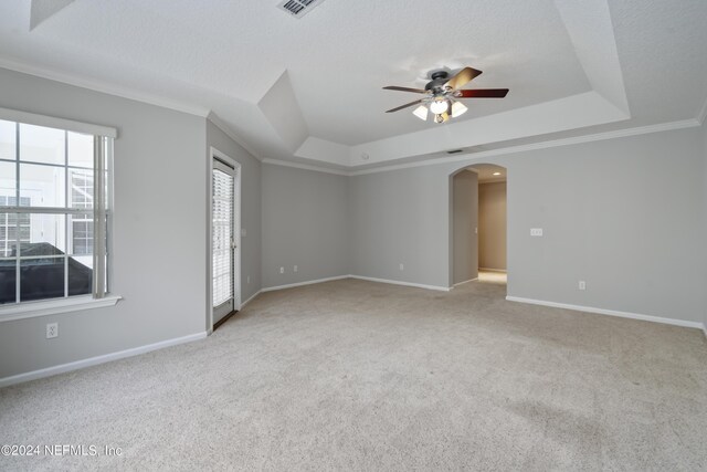 carpeted empty room with a textured ceiling, ornamental molding, a tray ceiling, and ceiling fan