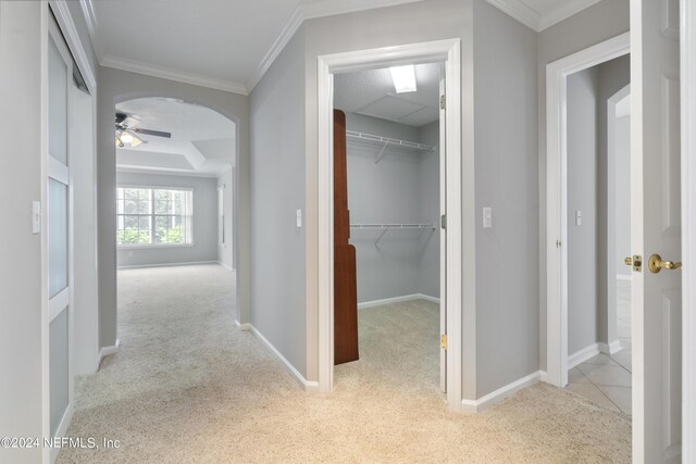 hallway with light colored carpet and crown molding