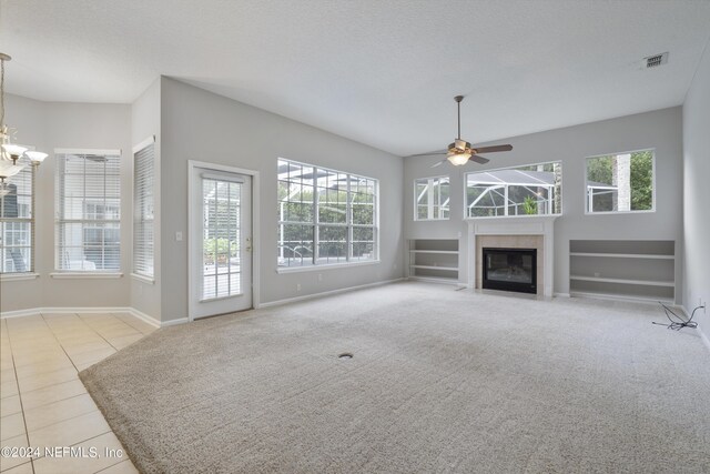 unfurnished living room featuring a textured ceiling, ceiling fan with notable chandelier, and light tile patterned floors