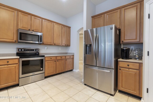 kitchen with appliances with stainless steel finishes and light tile patterned floors