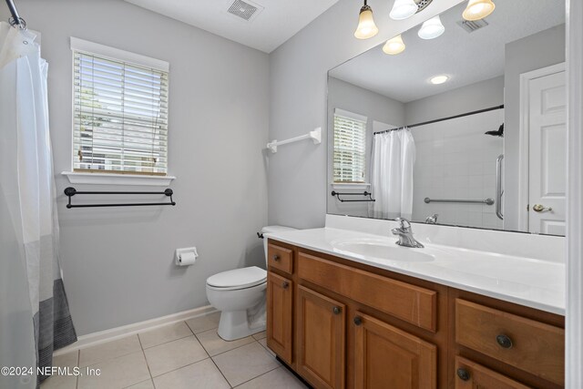 bathroom with a shower with curtain, vanity, tile patterned flooring, and toilet