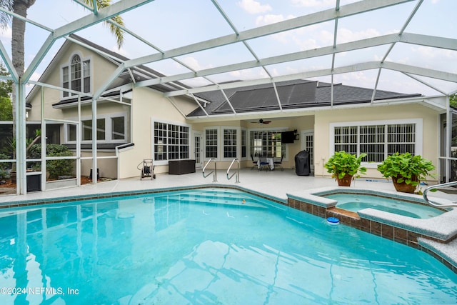 view of swimming pool featuring ceiling fan, a patio, an in ground hot tub, and a lanai