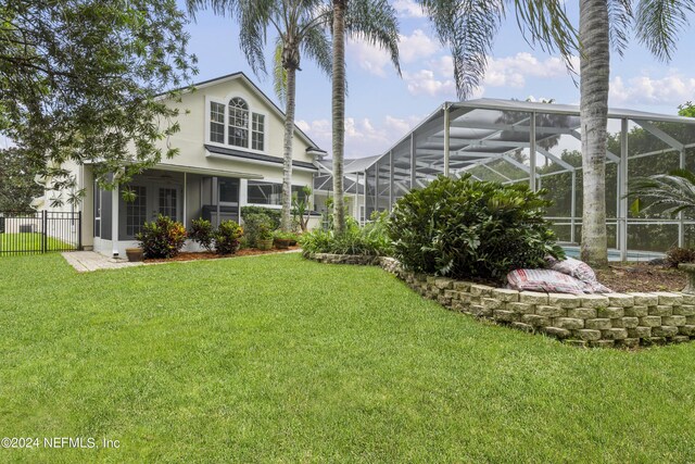 exterior space with a lawn and glass enclosure