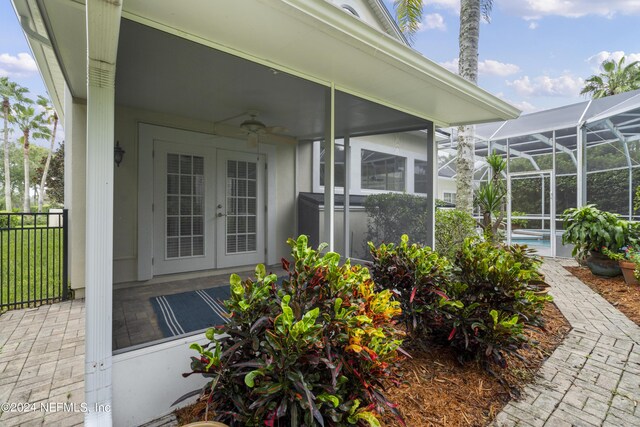 view of exterior entry featuring ceiling fan, french doors, and a patio area