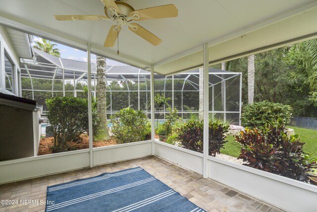 unfurnished sunroom featuring ceiling fan