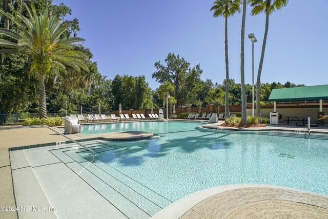 view of swimming pool with a patio and a hot tub