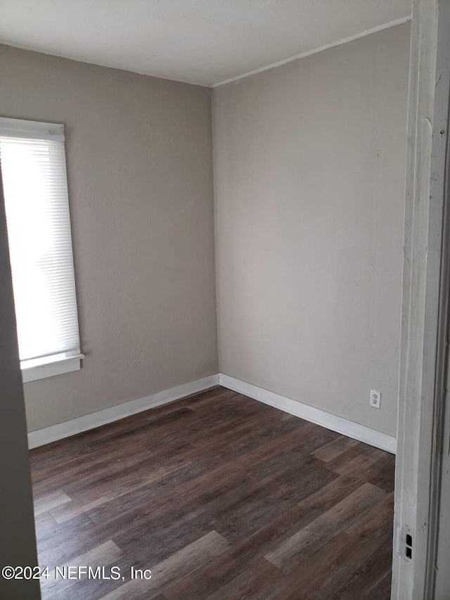 unfurnished room with dark hardwood / wood-style flooring