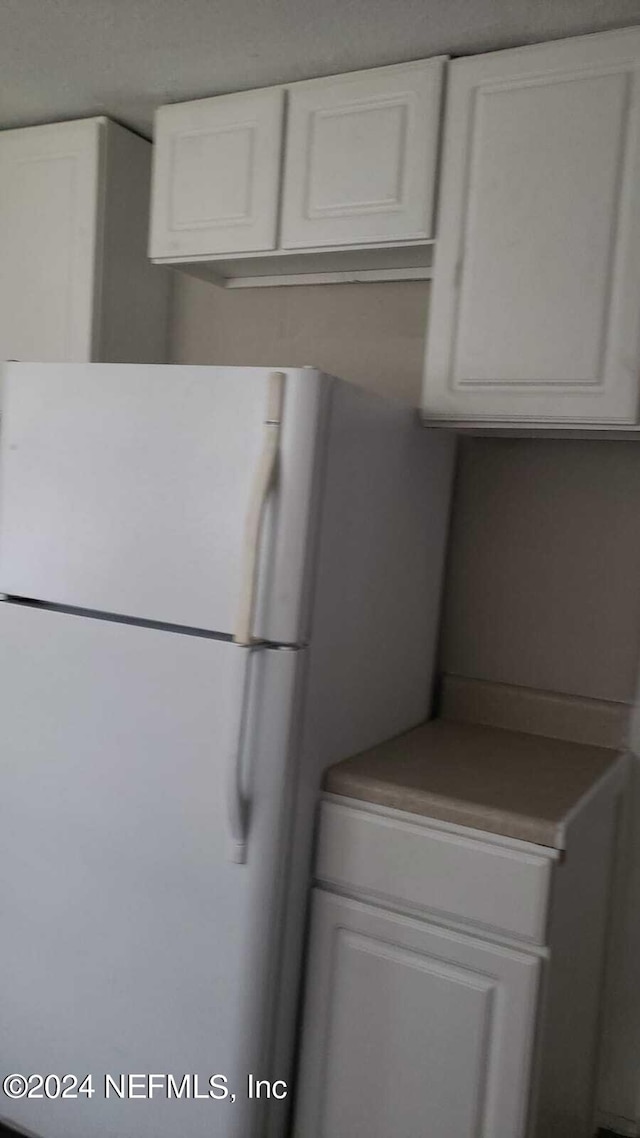 kitchen featuring white cabinetry and white refrigerator