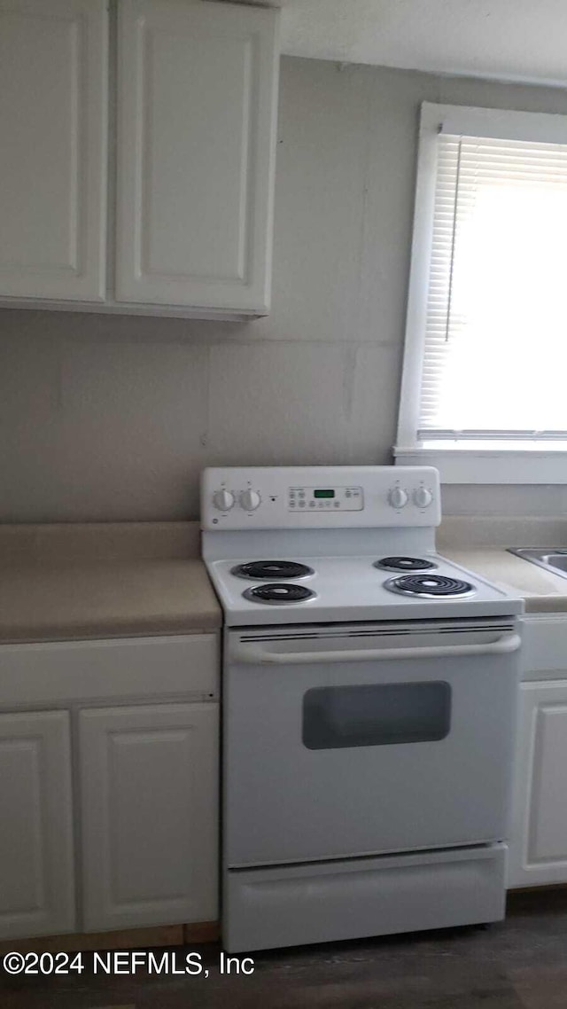 kitchen with white cabinetry, dark hardwood / wood-style floors, and electric range