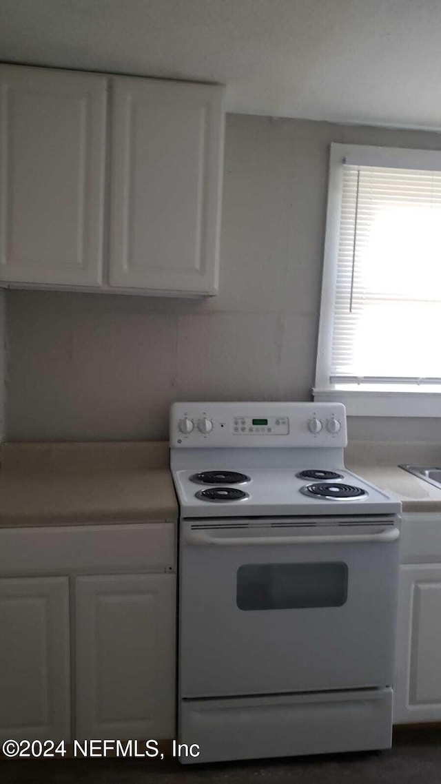 kitchen featuring white electric range and white cabinets