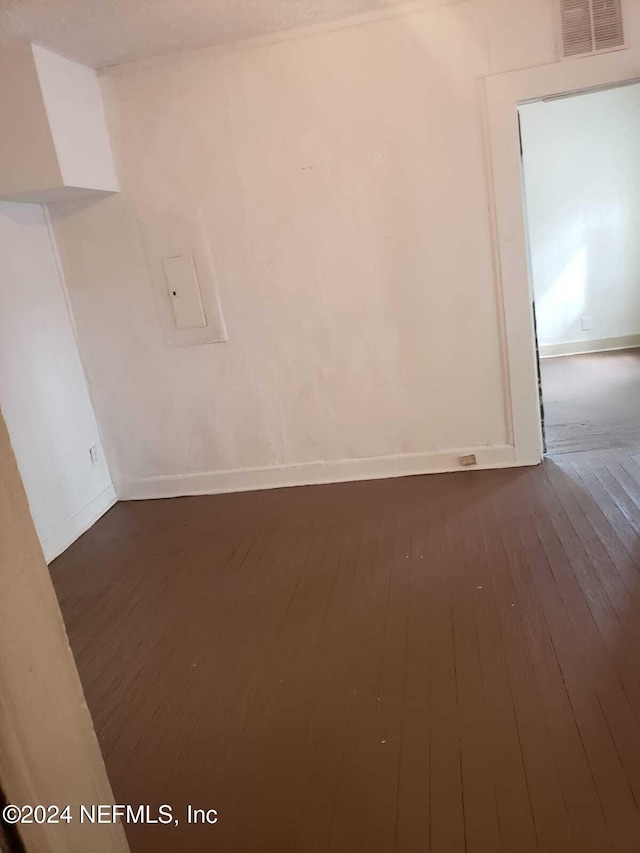 unfurnished room with dark hardwood / wood-style flooring