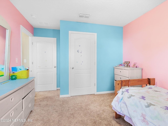 bedroom with a textured ceiling and light colored carpet