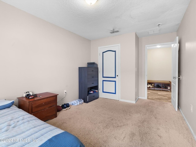 bedroom with light carpet and a textured ceiling