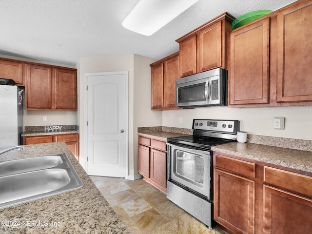 kitchen featuring sink, appliances with stainless steel finishes, and a textured ceiling