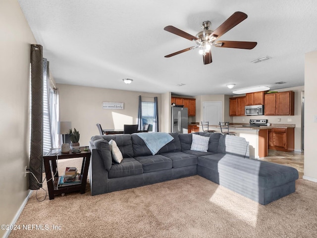 carpeted living room with a textured ceiling and ceiling fan