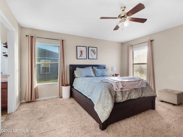 bedroom with connected bathroom, ceiling fan, and light colored carpet