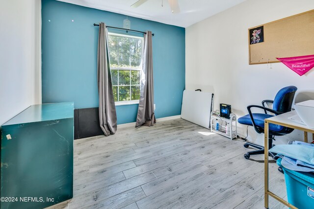 office with light hardwood / wood-style floors and ceiling fan