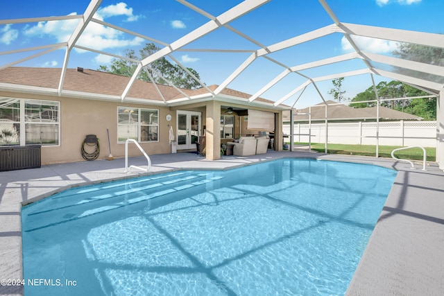 view of swimming pool with a patio, glass enclosure, and ceiling fan