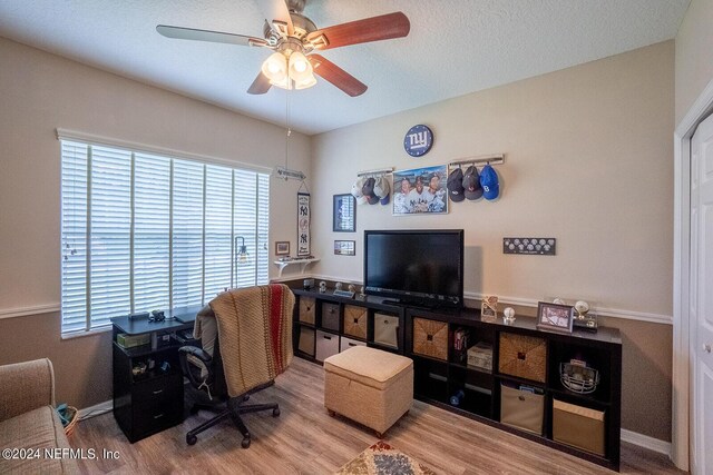 home office featuring ceiling fan, hardwood / wood-style flooring, and a textured ceiling