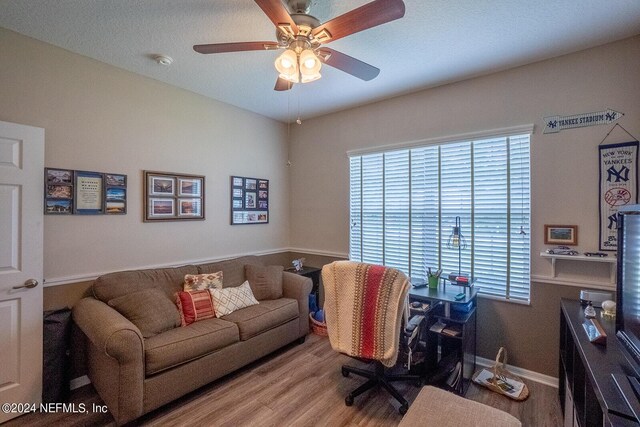 home office with wood-type flooring and ceiling fan