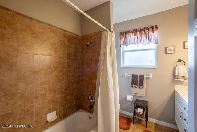 bathroom with tile patterned flooring, shower / bath combo, and vanity