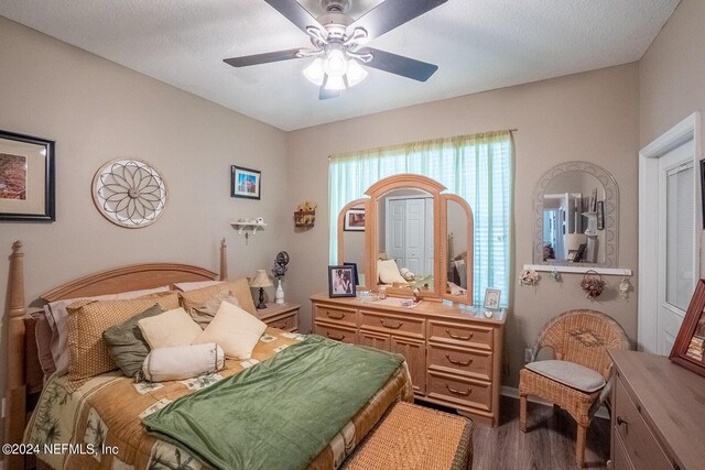 bedroom with a textured ceiling, hardwood / wood-style floors, and ceiling fan